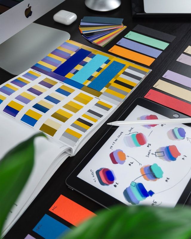 Image of a desk covered with colour charts and drawings. 
