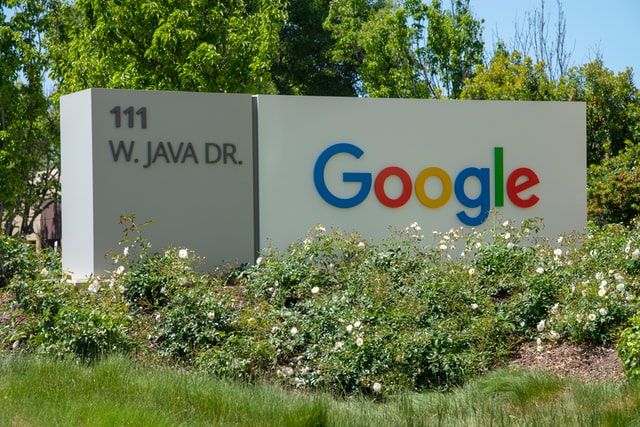 Picture of two large white walls, one with the address 111 W. Java drive and the other shoes the Google logo. 
