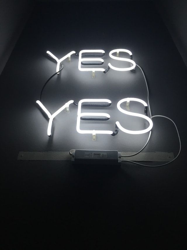 A black background with neon lights that say YES YES. Image by Michèle Eckert on Unsplash