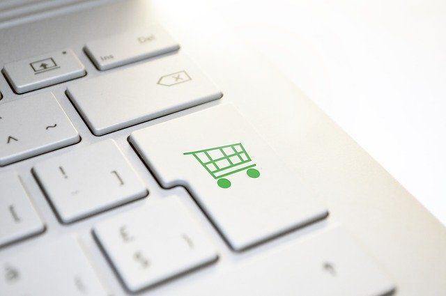 A photo of a mockup laptop keyboard where the enter key has been replaced with a green shopping cart logo. 